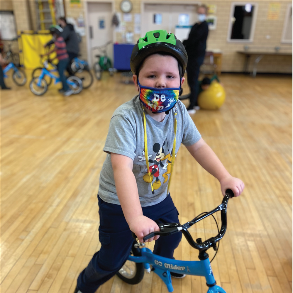  Student riding a bike in gym class.